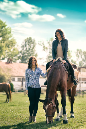 Two woman with horse, ranch for recreation and sportの写真素材