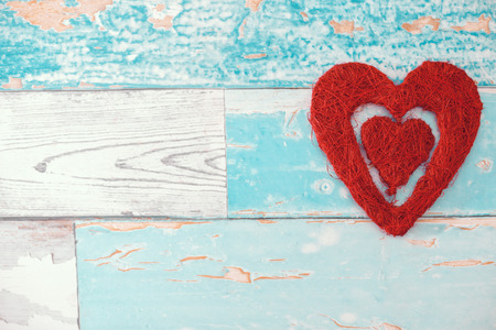 red wicker heart on wooden backgroundの写真素材