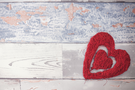 Romantic Valentines day heart on wooden background. Handmade wicker heart for Valentines day.の写真素材