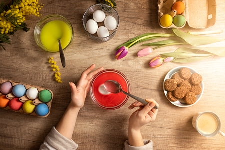 Close up of female hand decorating Easter eggs at homeの写真素材