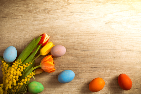 Colored Easter eggs on table over sunny spring day, Easter bannerの写真素材