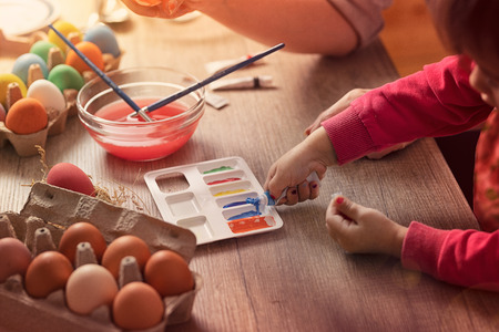 Painting Easter eggs and playing, little girl  sewing color getting ready to coloring eggsの写真素材