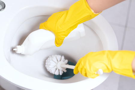 Hands in yellow gloves cleaning WC, toilet, lavatory using brushの写真素材