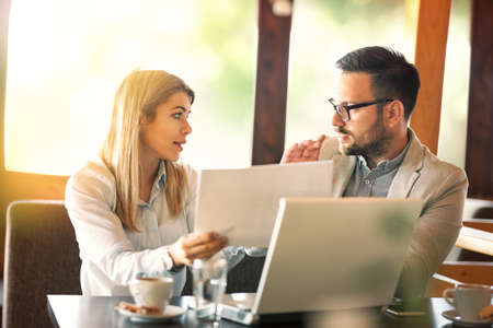 Two startup business colleagues having discussion in order to resolve problem on projectの写真素材