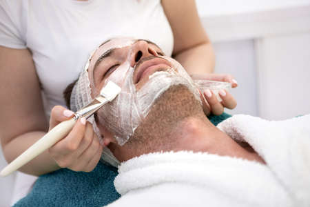 Young  man getting a facemask at the spa - beauty treatment conceptsの写真素材