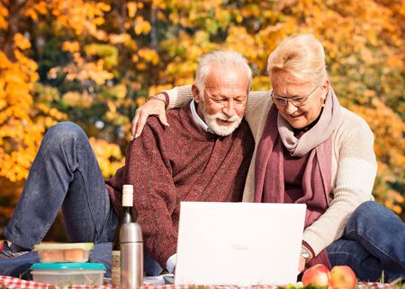 Attractive senior couple working on laptop â outdoorの写真素材