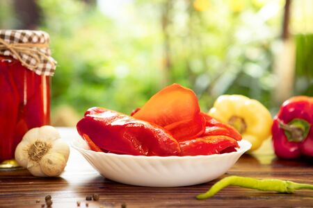 canned sweet pepper in glass jars and plate, homemade canning foodの写真素材
