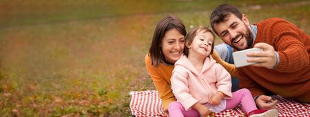 Young happy family doing selfie outdoor on picnicの写真素材