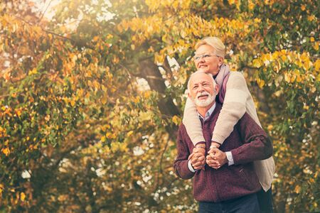 Senior woman affectionately embracing her husband at parkの写真素材