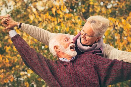 Vitality senior couple piggybacks in parkの写真素材