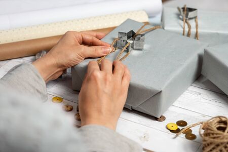 Female hands decorate gift for Christmas or New Year with cake moldsの写真素材