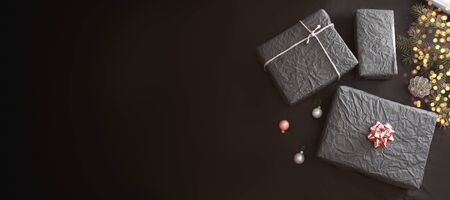 Christmas boxes wrapped with black paper on the table.