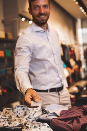 Handsome man pays at checkout clothesの写真素材