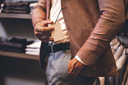 Man in a new suit shows a label. Brand matters, brand loyalty, branded goodsの写真素材