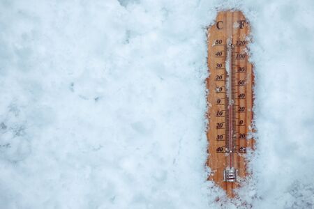 Top view on thermometer lying on layer of ice, showing low temperature. Concept illustrating extreme cold freezing weather in winter.の写真素材