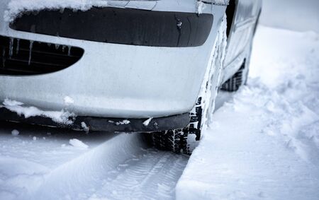 Close-up of car wheels rubber tires in deep winter snow. Transportation and safety concept.の写真素材