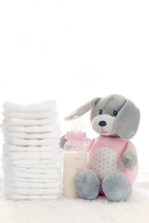 Baby background. Diapers and Teddy bear on softy bed ready for   babyの写真素材