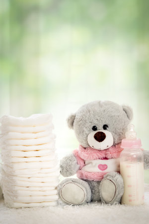 stack of diapers with soft teddy bear on table, hygiene conceptの写真素材