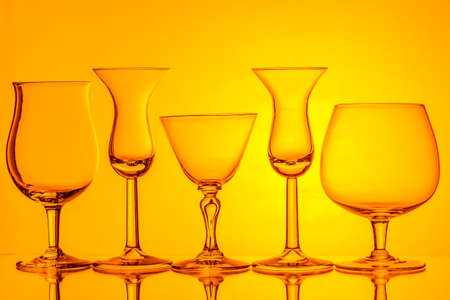 silhouette of wine glasses on orange background with space for textの写真素材