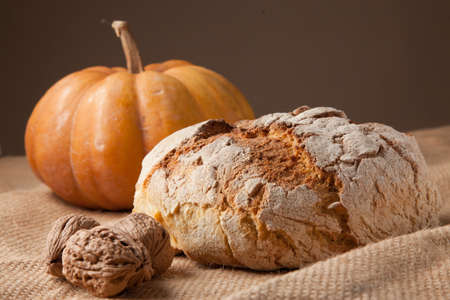 rustic autumn still life with bread pumkin walnuts.の写真素材