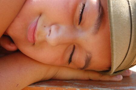 face of sleeping boy who put his head on the palmの写真素材