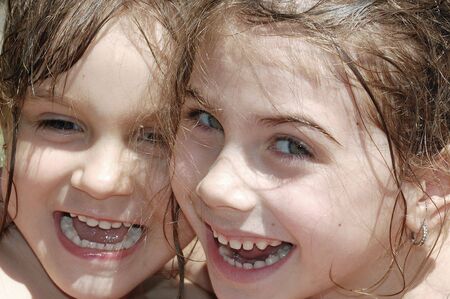 portrait of two happy smiling little girls with thier hair wetの写真素材