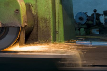 bright sparks of a spinning grinder at a factoryの写真素材