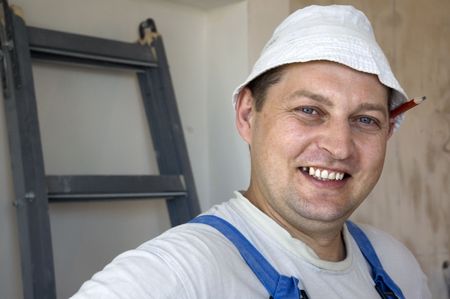 mature man worker wearing a uniform with a pencil behind his earの写真素材