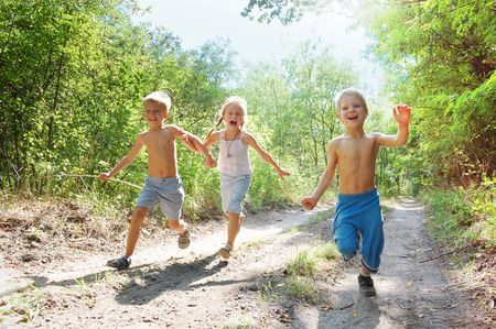 group of 5-6 year old happy kids running in the woods の写真素材