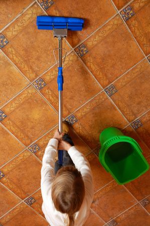 little girl washing the floor with swap