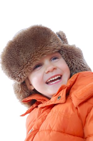 happy smiling girl in an orange coat and a flapped fur hat の写真素材