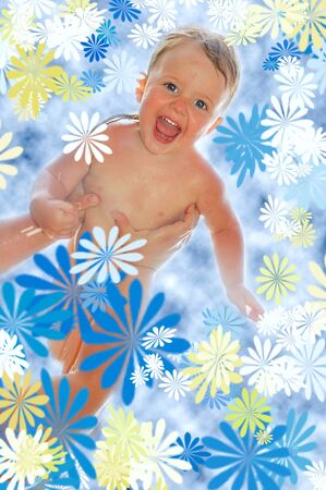 Happy baby boy high up in his momâ€™s hands surrounded with flowers