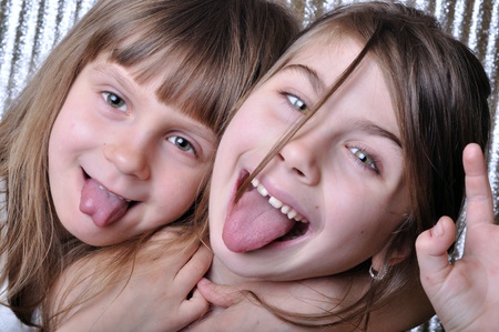 two playful girls with thier tongues outの写真素材