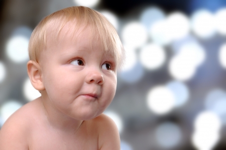 portrait of a happy toddler boy against  coloful shiny backgroundの写真素材