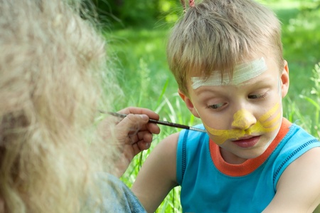 outdoor portrait of a child with his face being paintedの写真素材