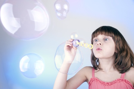 child blowing soap bubbles