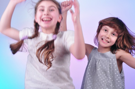 studio portrait of two joyful children having fun and dancingの写真素材