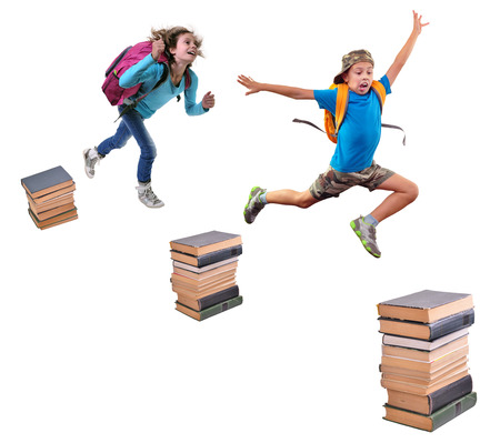 Portrait of a schoolchildren with backpacks leaping over piles of books. Childhood, education, learning conceptの写真素材