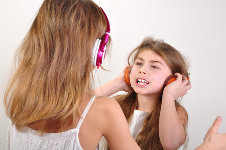 portrait of two children with headphones listening to musicの写真素材