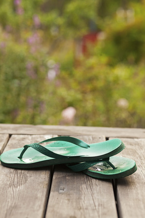 Flip flops on veranda overlooking a garden.の写真素材