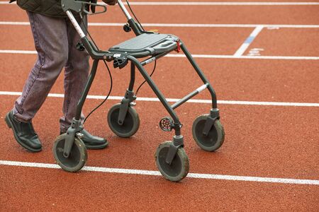 Stockholm, Sweden - May 15, 2016. Man with his walker on a racetrack, watching a race.のeditorial素材