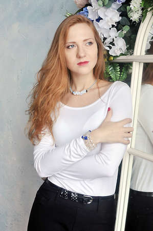 Girl with long red hair in a classic suitの写真素材