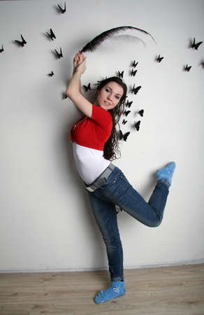 Girl in blue jeans is dancing with a black pen smilingの写真素材