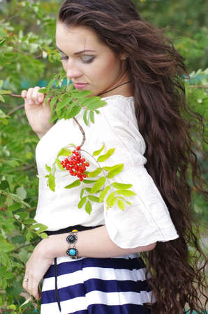 Beautiful girl with long dark hair on his head bowed rowanの写真素材