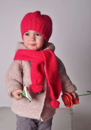 Little girl in pink knitted cap and scarfの写真素材