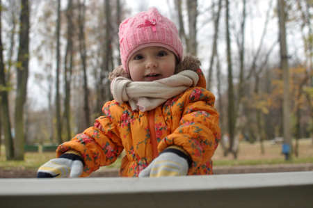 Little girl in a pink hat on a walkの写真素材