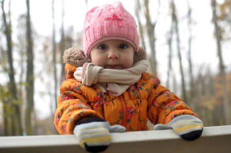 Little girl in a pink hat on a walkの写真素材