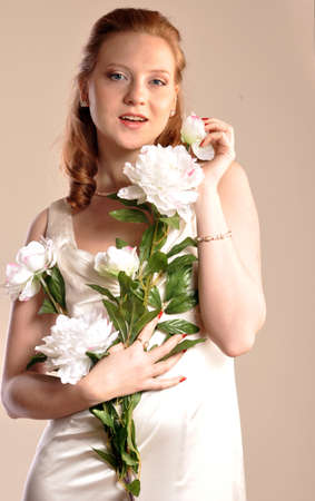 The girl with white flowers in hand smilingの写真素材