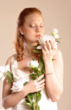 Portrait of red-haired girl with flowers in their handsの写真素材