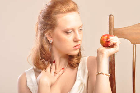 Young red-haired girl with an apple in his hand in the profileの写真素材